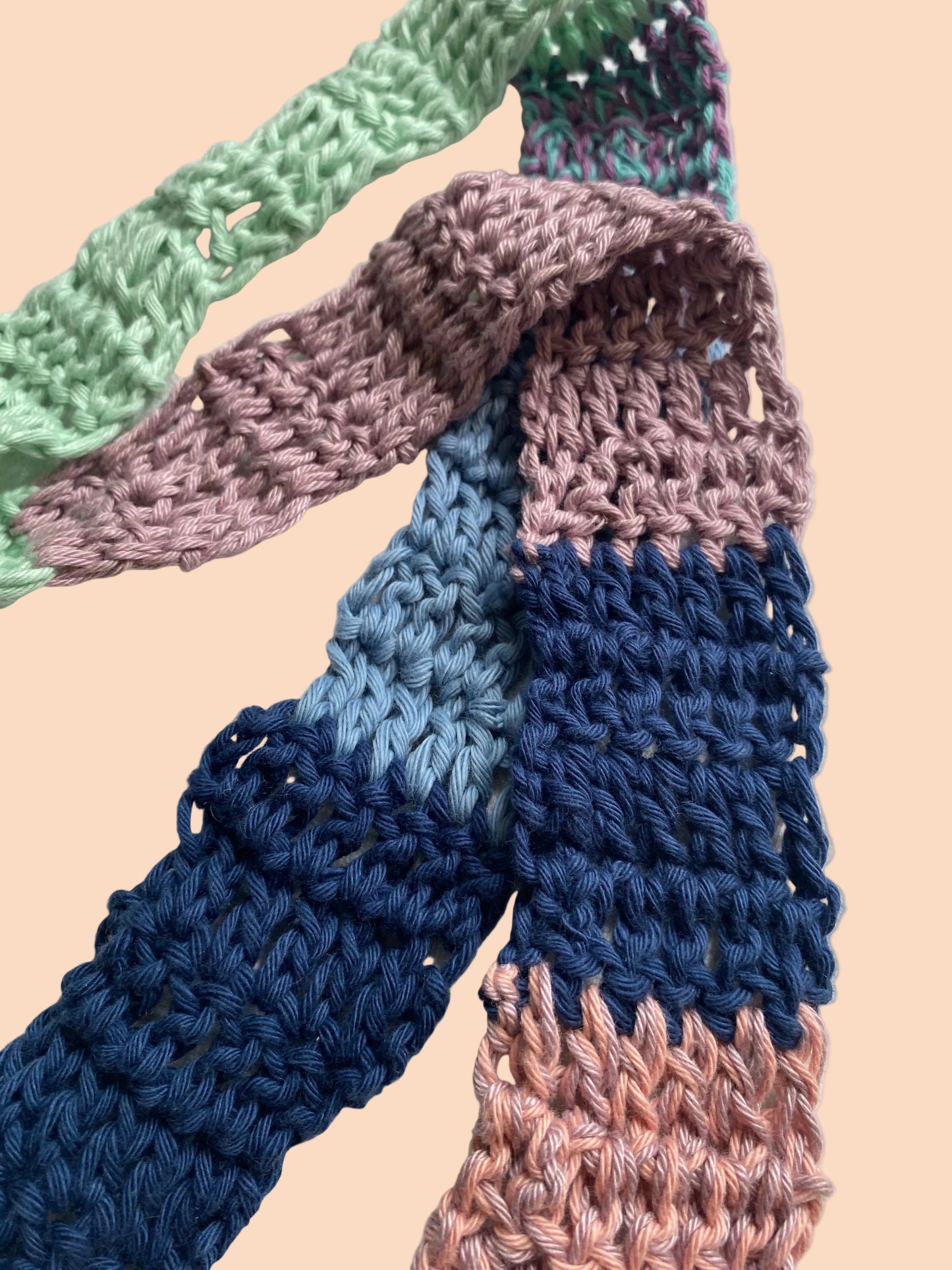 Colorful knitted scarf with gradient pattern on a light background