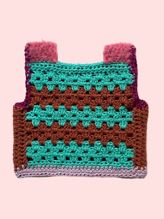Crocheted vest with pink straps and brown, green, and purple patterns 