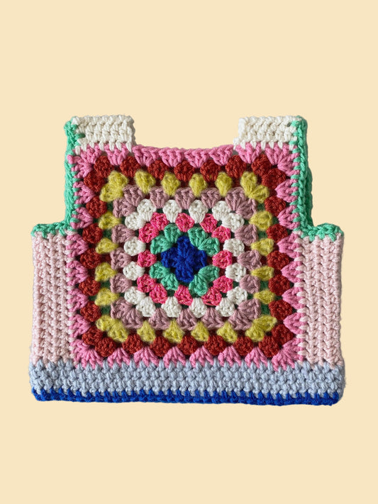 Colorful crocheted kid vest with a geometric pattern on a gray background