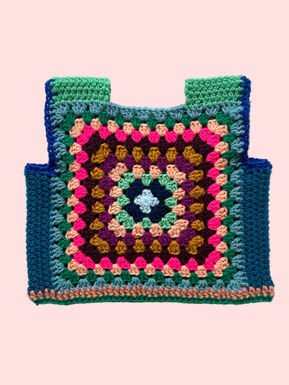 Colorful crocheted granny square vest on a white background