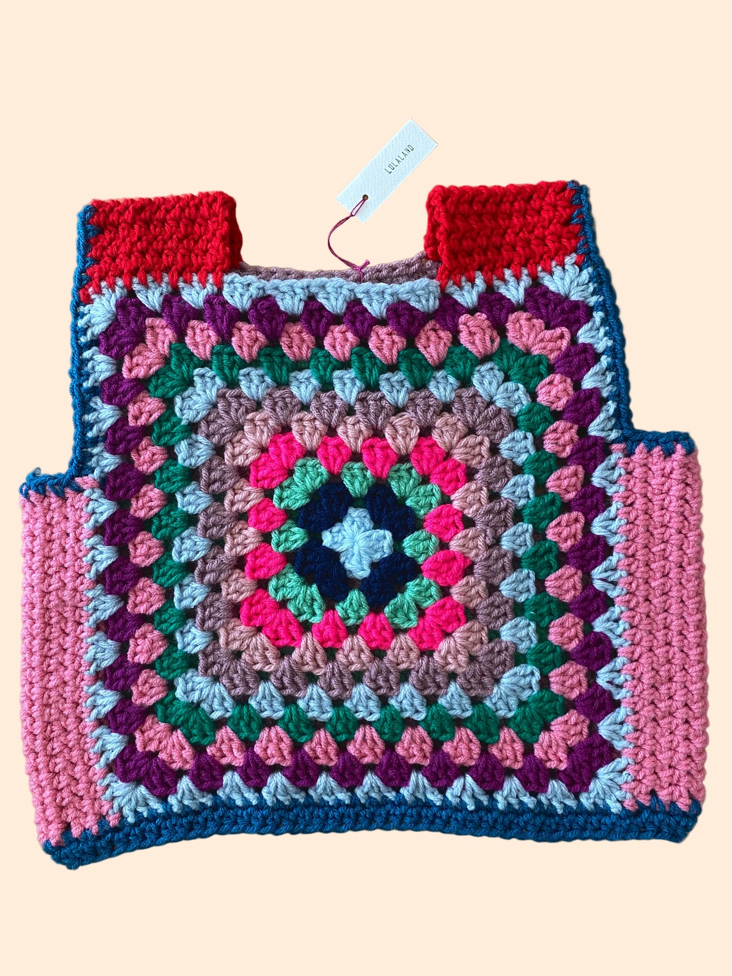 Colorful crocheted kid size vest with a geometric pattern 