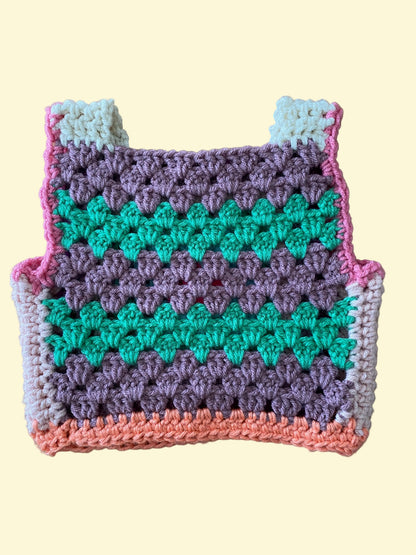 Crocheted vest with a colorful pattern on a wooden surface