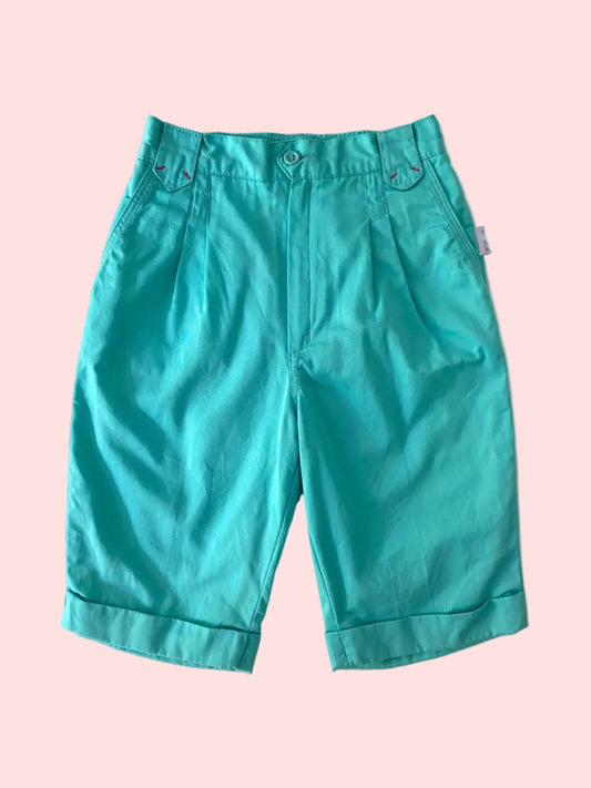 Teal capri pants on a textured white background