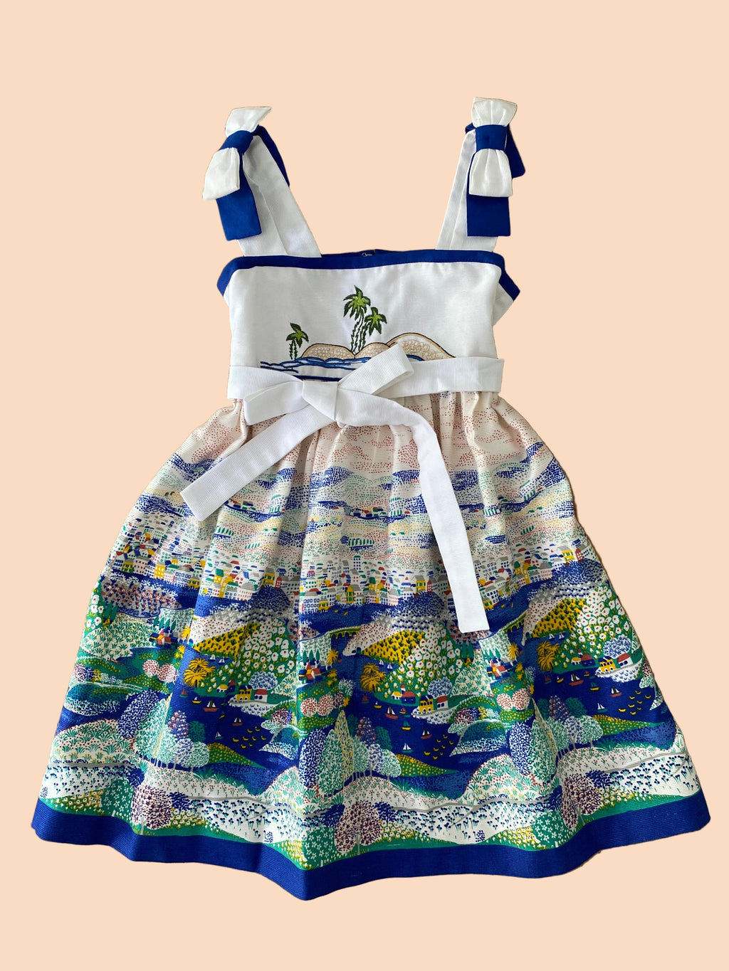 Children's dress with ocean-themed design on a wooden background