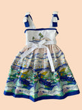 Children's dress with ocean-themed design on a wooden background