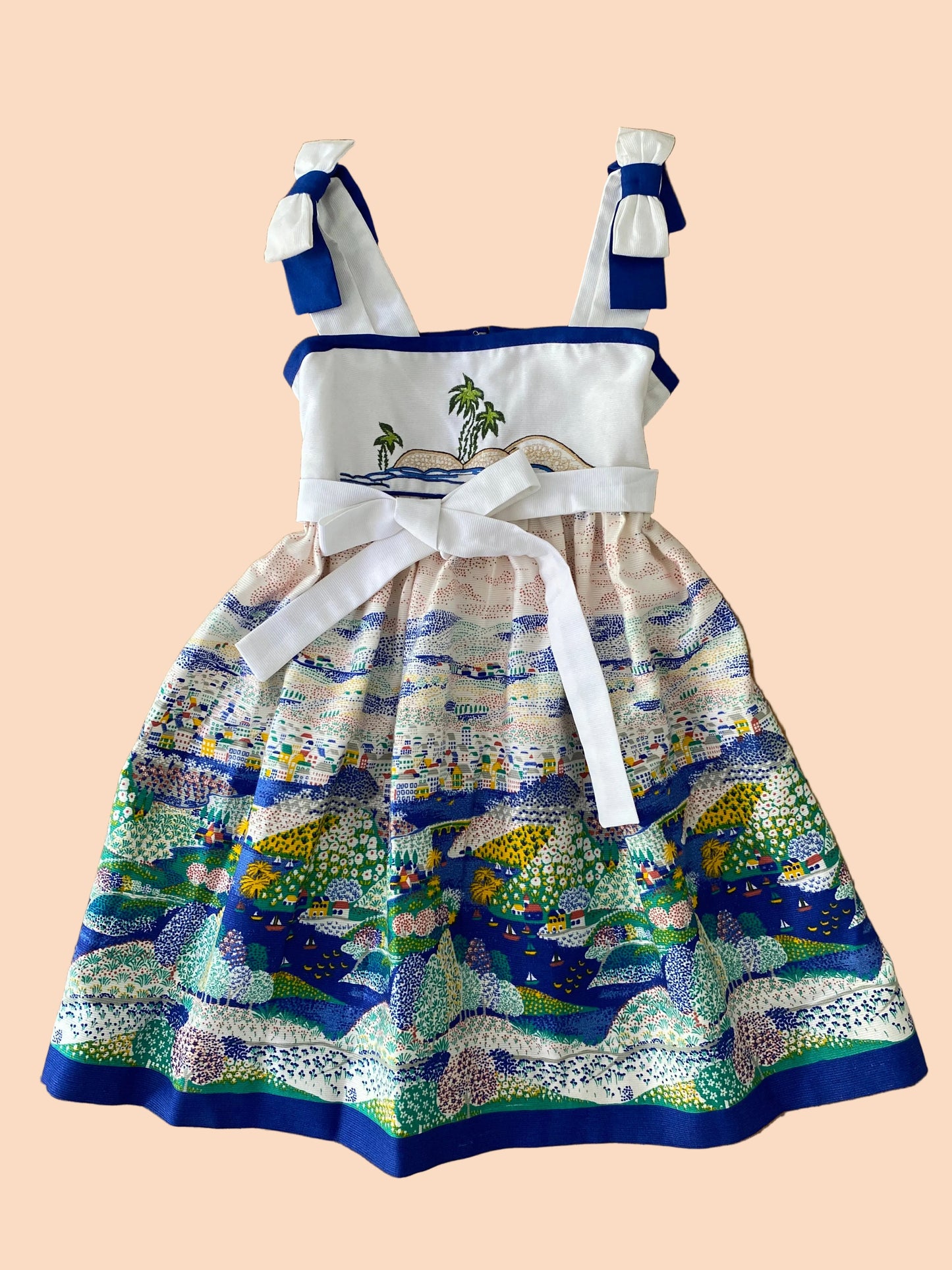 Children's dress with ocean-themed design on a wooden background