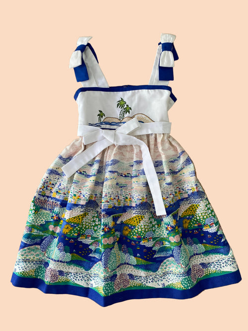 Children's dress with ocean-themed design on a wooden background