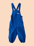 Blue overalls with a visible brand logo on a textured white background