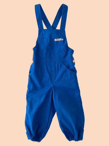 Blue overalls with a visible brand logo on a textured white background