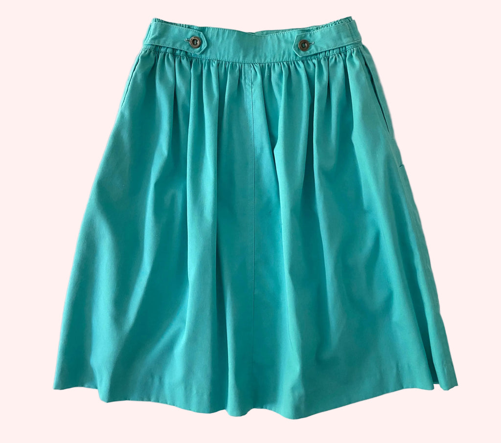 Teal skirt on a textured white background