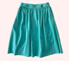 Teal skirt on a textured white background