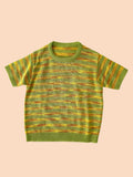 Green and yellow striped top on a textured white background