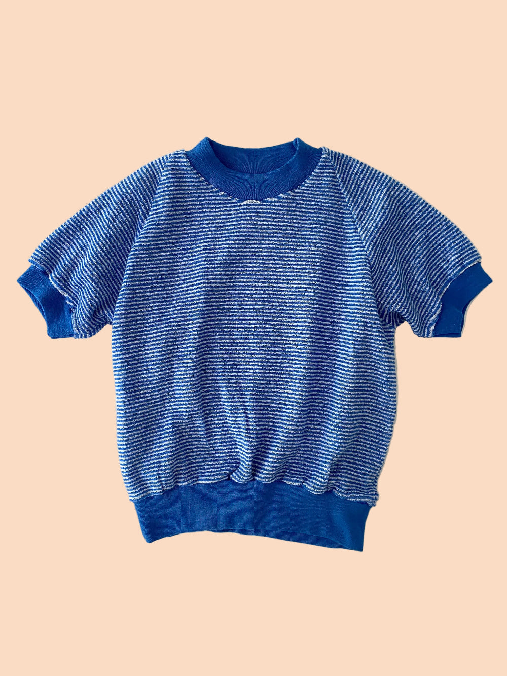 Blue striped sweater on a textured white background