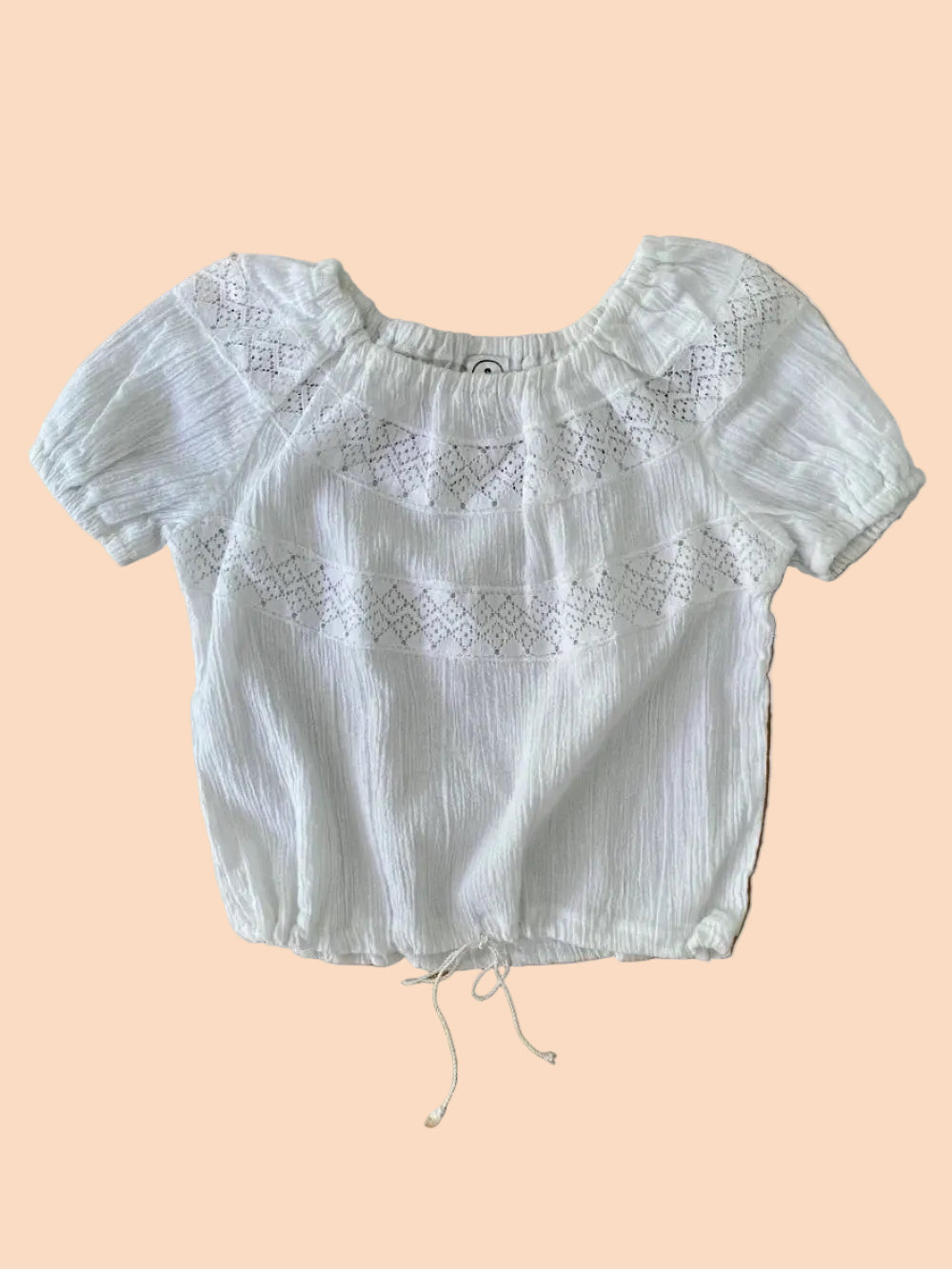 White blouse with lace details on a wooden surface