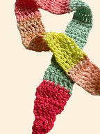 Colorful crocheted scarf on a light background