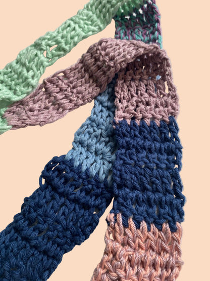 Colorful knitted scarf with gradient pattern on a light background