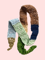 Colorful knitted scarf with gradient pattern on a light background